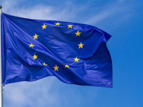 Flag Of The European Union Waving In The Wind On Flagpole Against The Sky With Clouds, Banner
